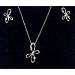 A diamond set 9ct white gold pendant and earrings set, comprising a floral wirework pendant set with