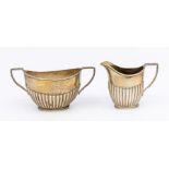 A matched Edwardian silver sugar bowl and milk jug, gadroon lower sections, both hallmarked by