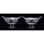 A pair of Victorian silver boat shaped bowls, ornate borders above pierced bodies with chased Neo-