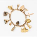 A 9ct gold charm bracelet suspending various 9ct and gilt charms, to include a 15ct gold Mermaid