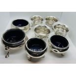 A collection of sterling silver salts. Featuring four scallop edge, footed salts without liners