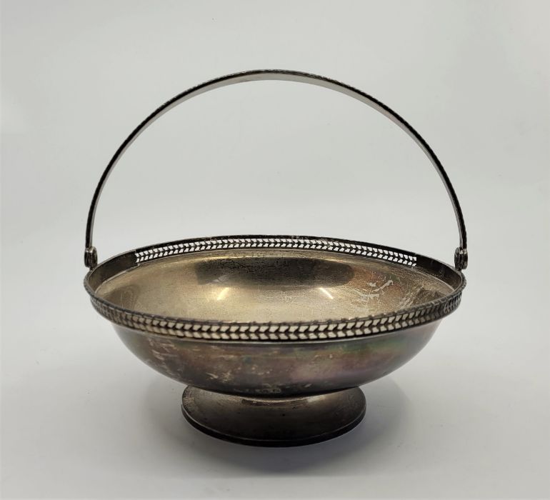 A silver swing handled pedestal basket, by Wilson & Gill, Birmingham 1914, having pierced rim,