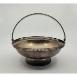 A silver swing handled pedestal basket, by Wilson & Gill, Birmingham 1914, having pierced rim,
