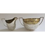 A Victorian silver twin-handled partly fluted oval sugar basin, 9.5cm high and matching cream jug