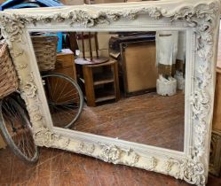 Large cream painted carved mirror with bevelled edge glass, decorated frame measures 5' x 4'