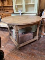 Solid heavy blond oak circular table in a refectory style over framed, braced leg base extending