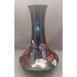 A 1947-1953 tall tube lined stylised Moorcroft vase, decorated with pansies of different colours