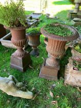 3 cast iron rusting garden urns two with plinths,
