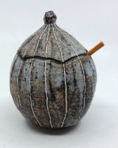 A Yo Thom. Stoneware lidded spice pot with wooden spoon. stands 8 cm tall to the rim of the base