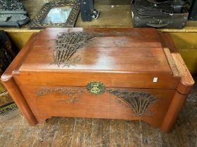 A carved chest depicting Chinese style birds and bamboo with brass furniture  Oriental hard wood