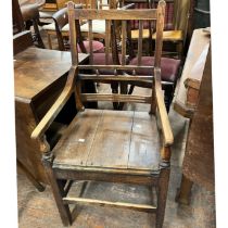 An early 19th century oak and elm open armchair, fluted and beaded splats, curved armrests on