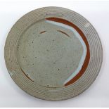 A David Leach (1911-2005). Stoneware plate, impressed mark DL. measuring 27cm across Condition: