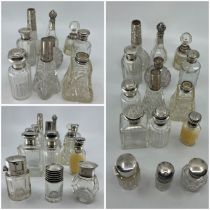 A collection of fifteen assorted cut glass scent bottles and toilet jars each with silver mounts