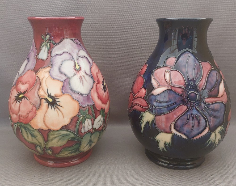 2  tube lined stylised Moorcroft vases, one decorated with multi coloured pansies with a burgundy