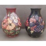 2  tube lined stylised Moorcroft vases, one decorated with multi coloured pansies with a burgundy