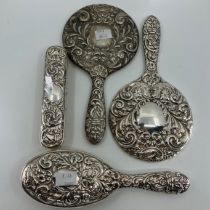 A Victorian style dressing table set, the silver mounts repousse with foliate scrolls, masks and