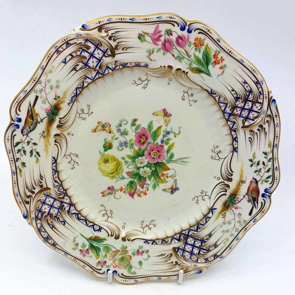 A 19th century Coalport plate, the centre painted with flowers and butterflies, the moulded shaped
