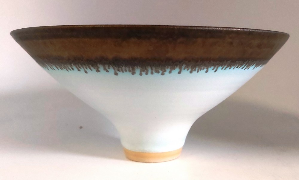 A porcelain footed bowl after Lucie Rie with bronzed decoration to rim.   Impressed mark A. (