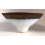 A porcelain footed bowl after Lucie Rie with bronzed decoration to rim.   Impressed mark A. (