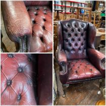 Oxblood traditional button back and seated Chesterfield Wing back chair on queen anne style legs.