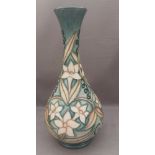 A  tall tube lined stylised Moorcroft vase, decorated with daffodil flower heads and leaves with a