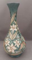 A  tall tube lined stylised Moorcroft vase, decorated with daffodil flower heads and leaves with a