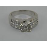 18ct white gold 2.5ct diamond ring with additional diamond set shoulders of 15 stones each.