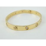 18ct gold Cartier Love bangle inset with 10 diamonds. Numbered AG034512