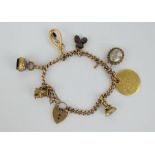 9ct gold charm bracelet with charms including 15ct gold, two fob seals and a George III gold guinea