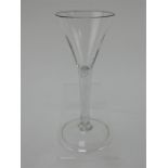 An 18th century drinking glass with trumpet bowl, tear drop stem and folded foot. Height 15.5cm