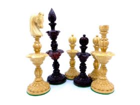 A set of carved wooden lotus chess pieces housed in an unrelated chess box