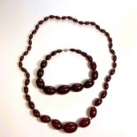 Two strands of early 20th century cherry bakelite type beads. Comprising a clasp-less strand of