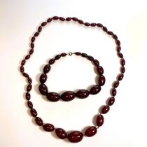 Two strands of early 20th century cherry bakelite type beads. Comprising a clasp-less strand of