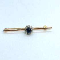 An Circa 1900s sapphire and diamond bar brooch. Featuring a central dark blue sapphire in an oval