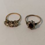 Two 9ct gold cubic zirconia set rings. Comprising a three stone set CZ ring, size M1/2; plus a red
