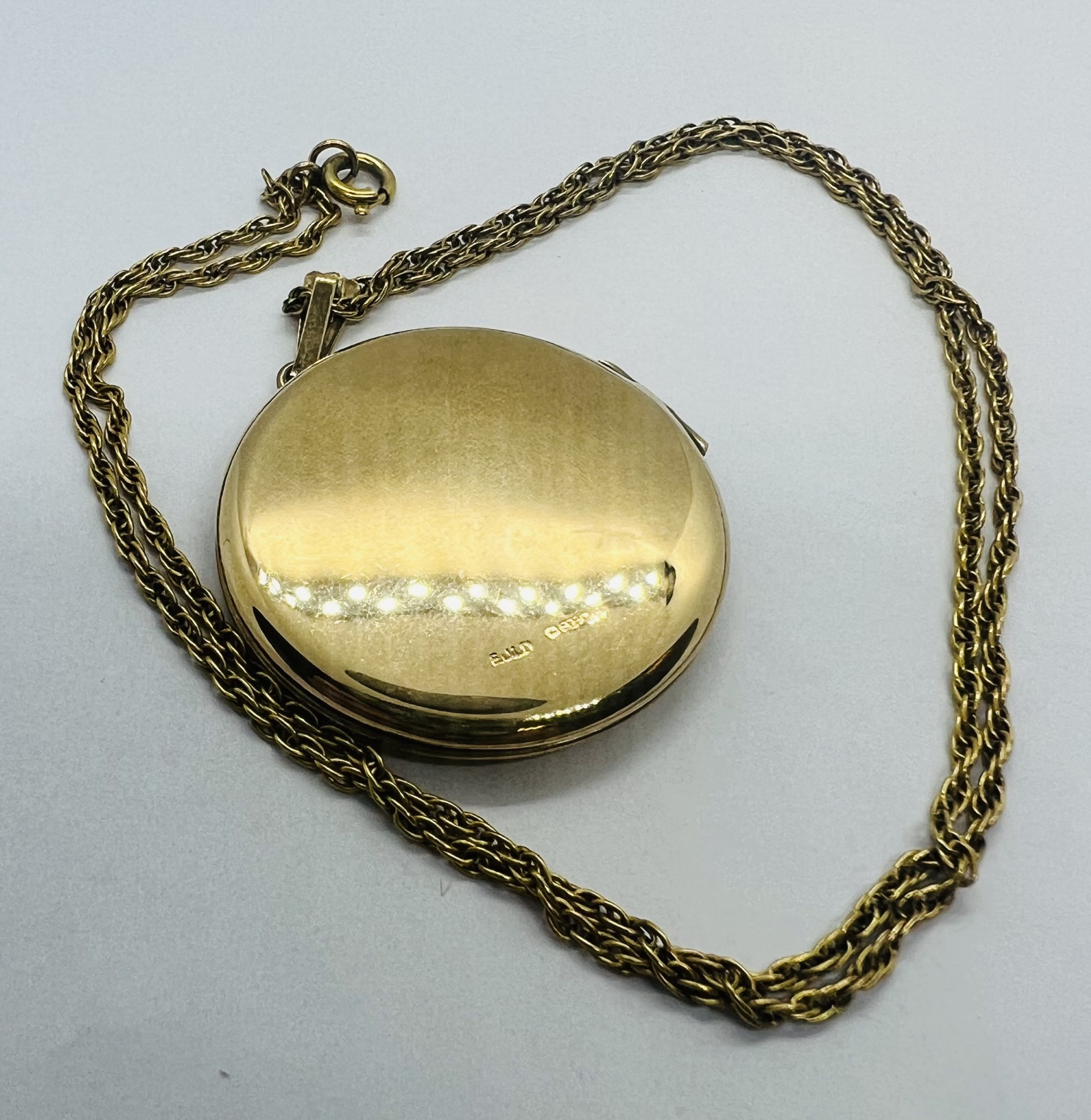 A 9ct circular locket with foliate engraving on a "9ct" stamped chain. Gross approximate weight 9. - Bild 2 aus 4