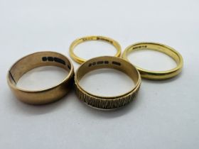 A collection of four yellow gold band rings. Comprising a 22ct gold band ring (size M; approximate