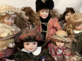 Collection of Many modern  Porcelain child dolls in original clothing inc a winter coat hat set