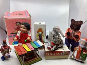 A good Selection of Vintage wind up clockwork toys to include a child doll at a xylophone, an