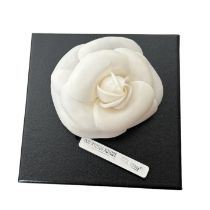 A Chanel camelia brooch in a soft white silk with curved petals and a gold tone pin with rollover