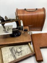 A rather wonderful Childs toy sewing working machine with wooden base and clamp and cover , made