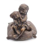 Bronze figure of a little girl holding a puppy on a cushion