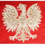 A mid 20th century Polish woollen carpet/rug of red ground with a Polish eagle motif to the