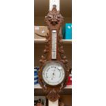 A 20th century Reynolds & Sons of London carved oak barometer with leaf design. Approx. 88cm long.