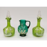 A pair of 19th century green glass decanters in the style of Mary Gregory, together with a green