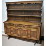 A mid 20th century solid oak carved Old Charm dresser with detachable plate rack, three drawers