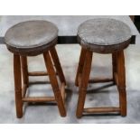 A pair of oak bar stools with green leather seats.