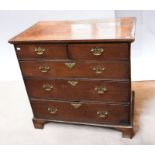 A George III oak chest of two over three drawers, on bracket feet, brass swing handles