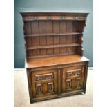 A Victorian oak dresser having plate rack above two cupboards, on block feet, along with a mid