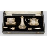 A cased George VI silver three piece condiment set comprising mustard pot, salt cellar, pepper pot